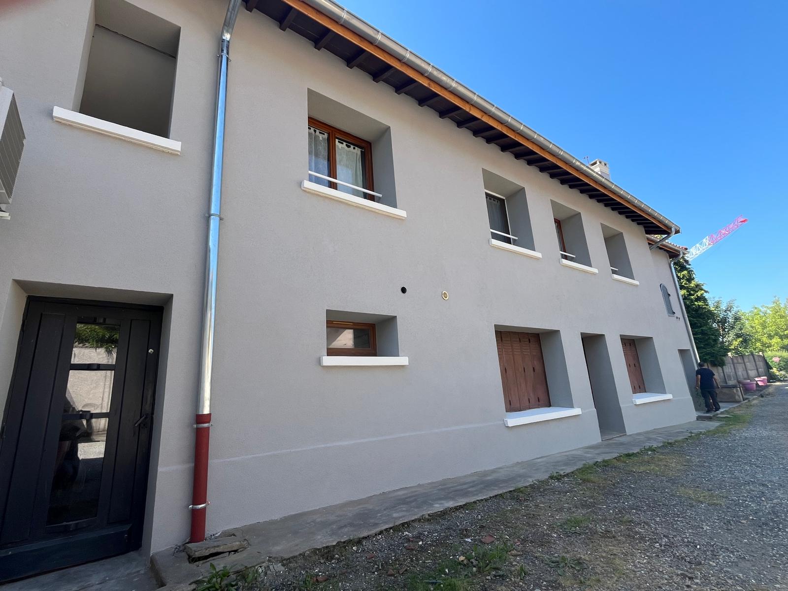 Façade grise rénovée avec encadrements blancs